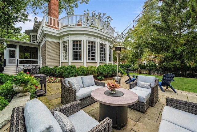 view of patio / terrace with a balcony, a sunroom, fence, and outdoor lounge area