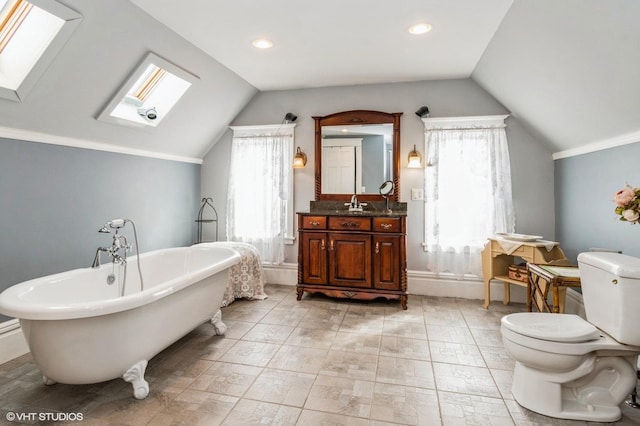 bathroom with plenty of natural light, vaulted ceiling with skylight, a freestanding bath, and toilet