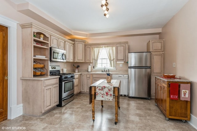 kitchen with light brown cabinets, open shelves, a sink, stainless steel appliances, and light countertops