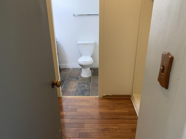 bathroom with hardwood / wood-style flooring and toilet