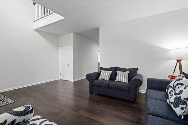 living area featuring baseboards, visible vents, and wood finished floors