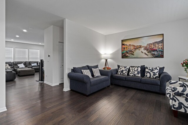 living area with dark wood-type flooring, recessed lighting, and baseboards