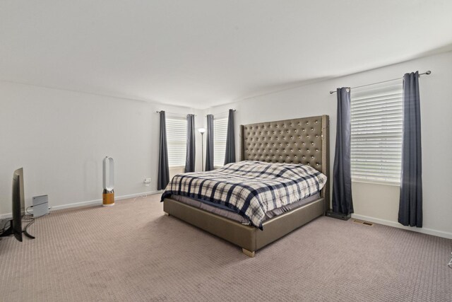 bedroom featuring baseboards, carpet flooring, and visible vents