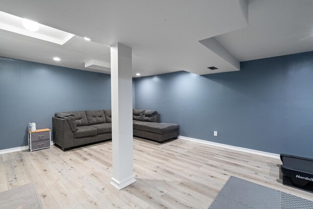 finished below grade area with baseboards, recessed lighting, and wood finished floors