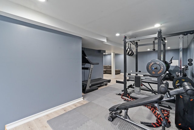 workout room featuring baseboards, recessed lighting, and wood finished floors