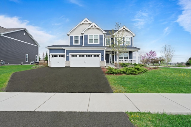 craftsman-style house featuring aphalt driveway, stone siding, a front yard, board and batten siding, and a porch