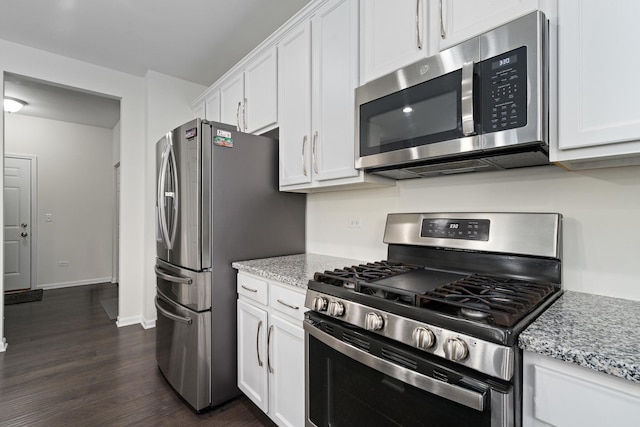 kitchen with light stone countertops, stainless steel appliances, dark wood finished floors, and white cabinetry