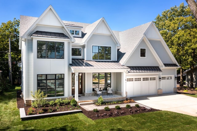 modern inspired farmhouse featuring a porch, a garage, and a front yard