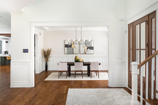 dining space featuring ornamental molding, a notable chandelier, and dark hardwood / wood-style flooring