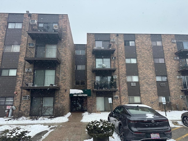 snow covered property featuring uncovered parking