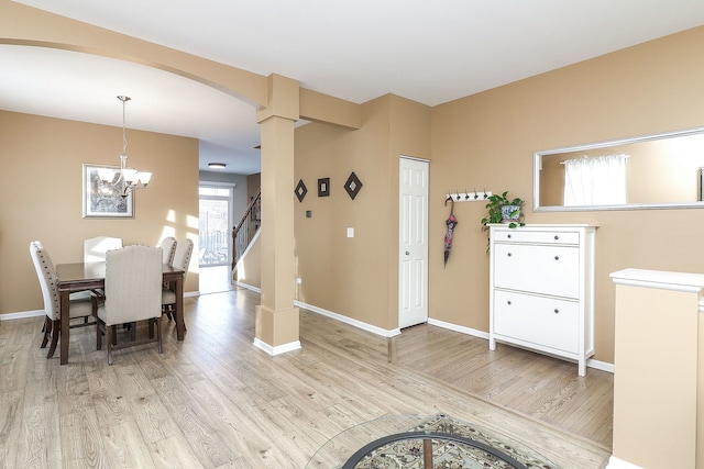 dining space featuring light wood-style flooring, baseboards, and an inviting chandelier