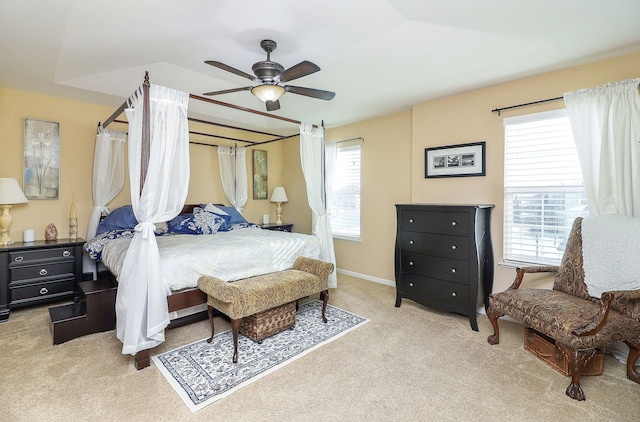 bedroom featuring light carpet, ceiling fan, and multiple windows