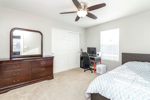 bedroom featuring a closet, light colored carpet, and ceiling fan