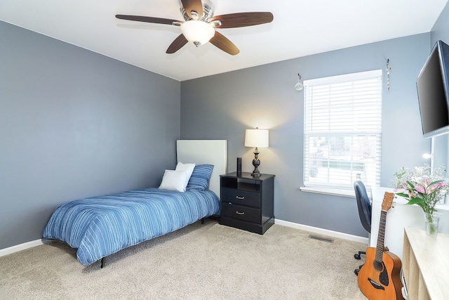 bedroom featuring light carpet, a ceiling fan, visible vents, and baseboards