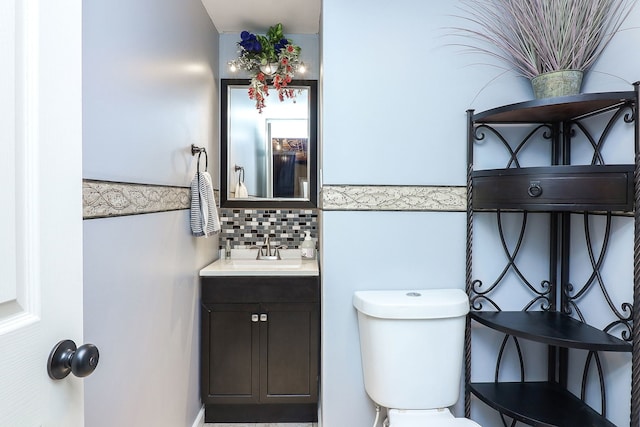 bathroom featuring tasteful backsplash, vanity, and toilet