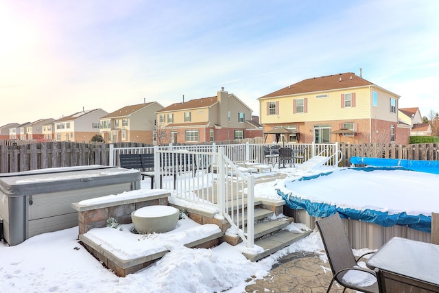 exterior space featuring a wooden deck, fence, a residential view, and a hot tub