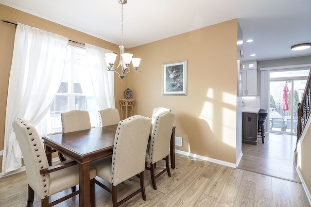 dining room featuring light wood-style floors, baseboards, a notable chandelier, and recessed lighting