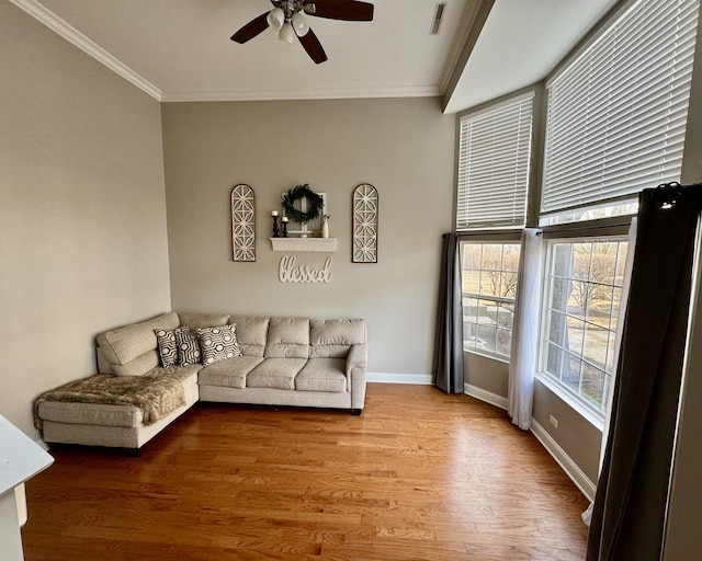 living room featuring visible vents, ornamental molding, wood finished floors, baseboards, and ceiling fan