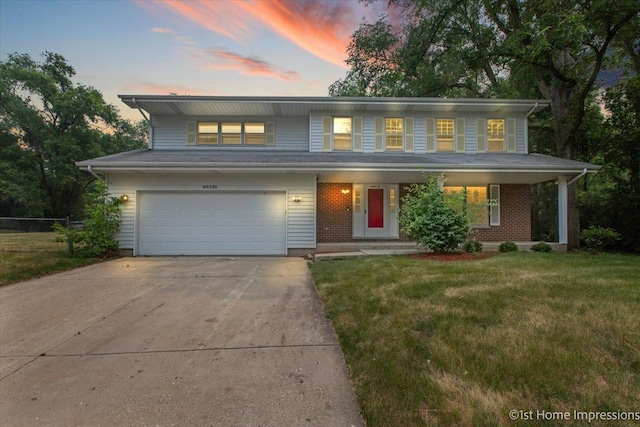 view of front of house with a yard, a garage, and a porch