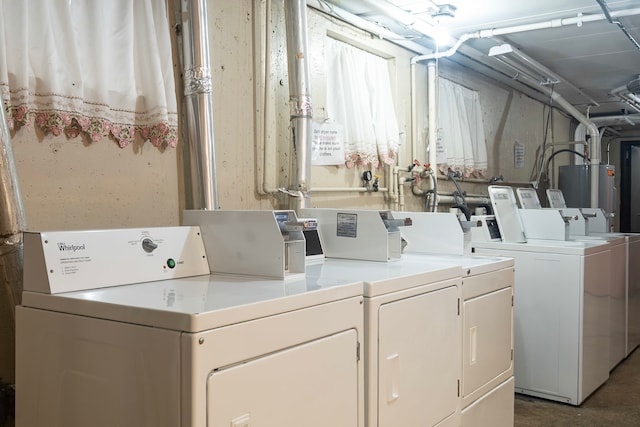 clothes washing area with water heater and separate washer and dryer