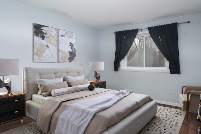 bedroom with baseboards and wood finished floors