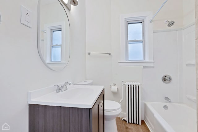 full bathroom featuring washtub / shower combination, radiator heating unit, toilet, vanity, and hardwood / wood-style floors