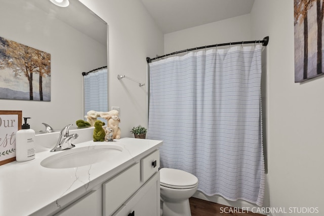 bathroom featuring walk in shower, vanity, and toilet