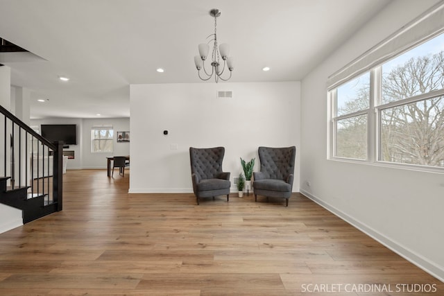 sitting room with a notable chandelier and light hardwood / wood-style floors