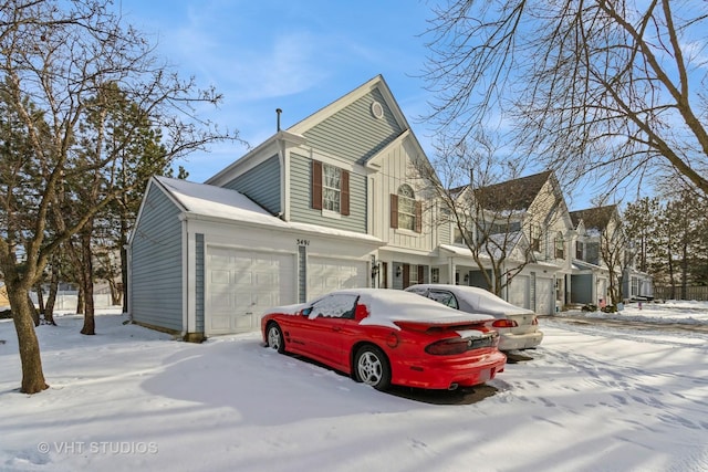 view of snowy exterior featuring a garage