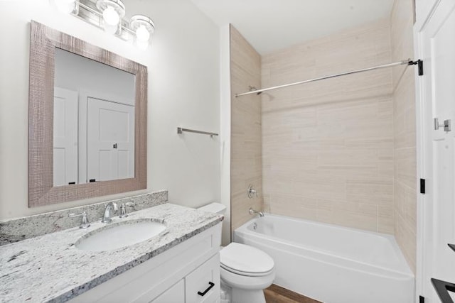 full bathroom featuring vanity, tiled shower / bath combo, and toilet