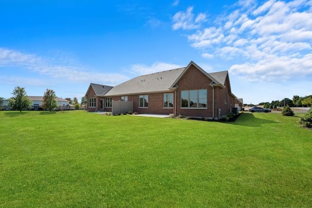 rear view of property with a yard and a patio area