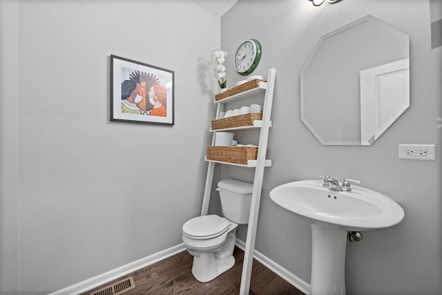 bathroom with hardwood / wood-style flooring and toilet