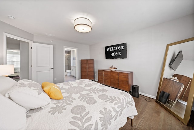 bedroom featuring hardwood / wood-style flooring and ensuite bath