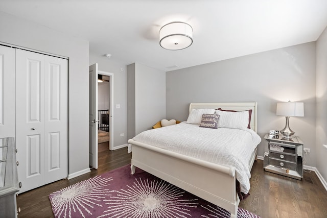 bedroom with dark wood-type flooring and a closet