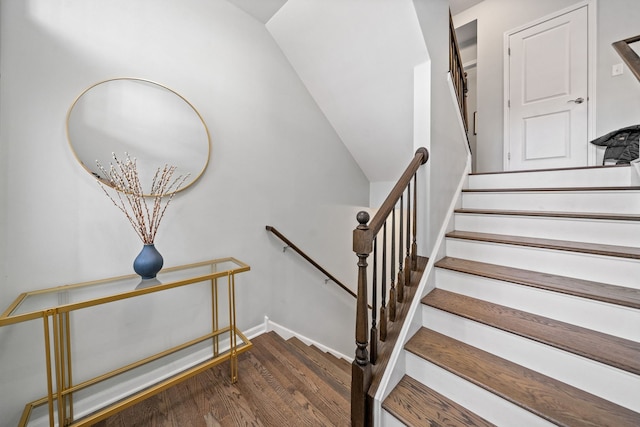 stairs featuring lofted ceiling and wood-type flooring