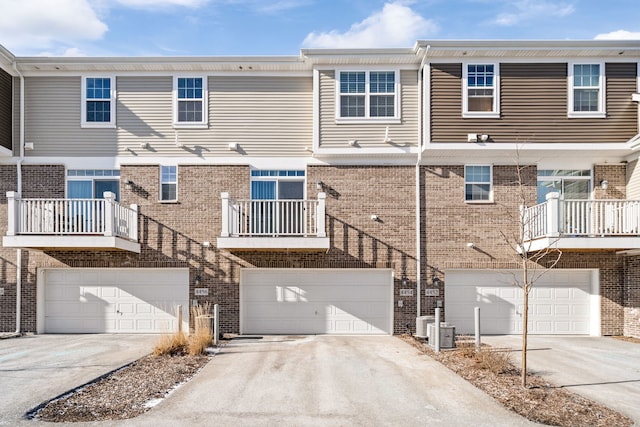 rear view of property featuring a garage and central air condition unit