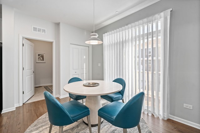 dining space with wood-type flooring