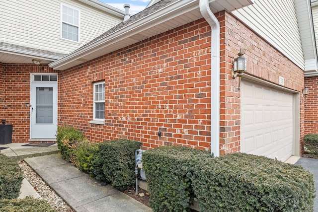 entrance to property with brick siding and an attached garage