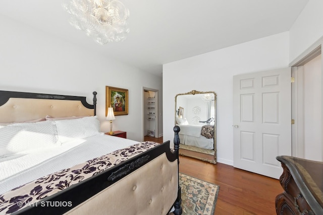 bedroom with an inviting chandelier and dark hardwood / wood-style flooring