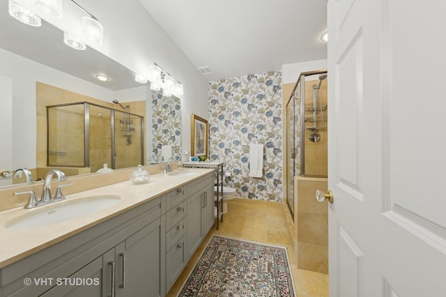 bathroom with tile patterned flooring, toilet, vanity, and walk in shower