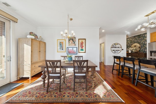 dining space featuring ornamental molding, dark hardwood / wood-style floors, and an inviting chandelier