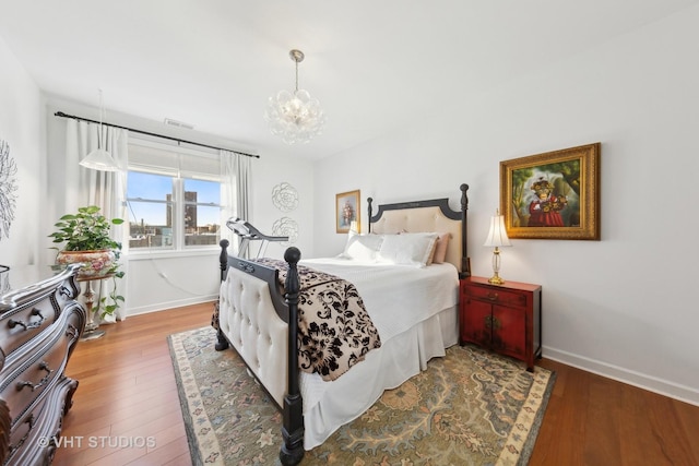 bedroom featuring hardwood / wood-style floors and an inviting chandelier