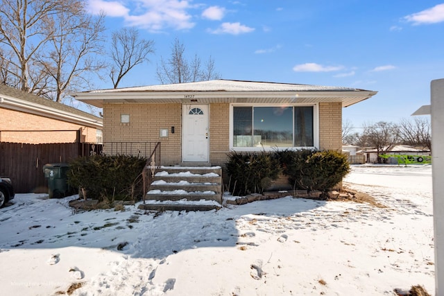 view of front of home with a shingled roof, entry steps, and brick siding