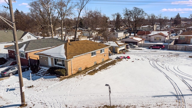 snowy aerial view with a residential view