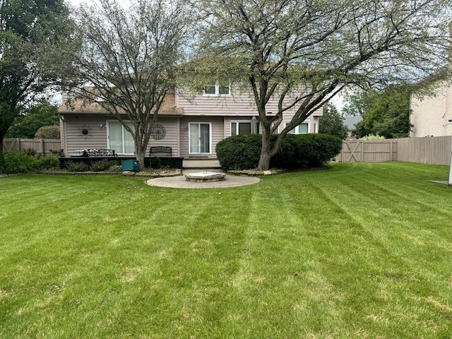 rear view of property featuring a patio, fence, and a lawn