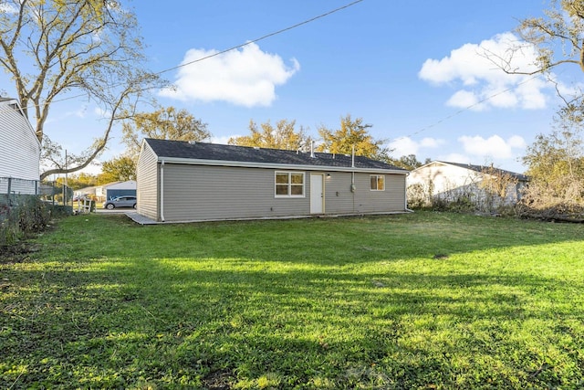 rear view of house featuring a lawn