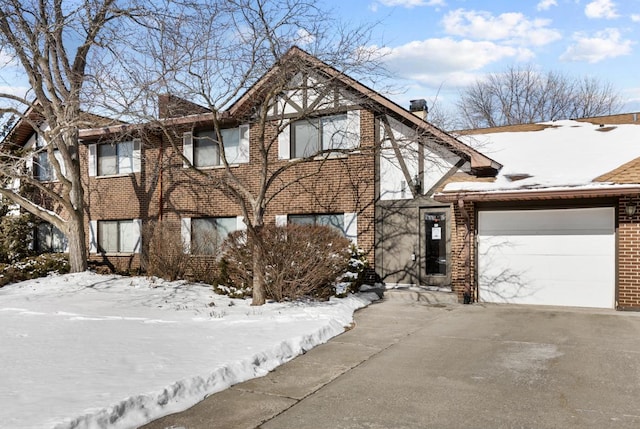 view of front of property featuring an attached garage, driveway, and brick siding