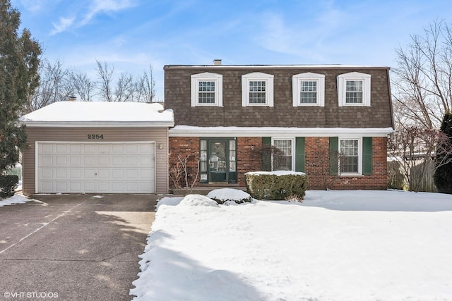 view of front of home featuring mansard roof, concrete driveway, a shingled roof, a garage, and brick siding