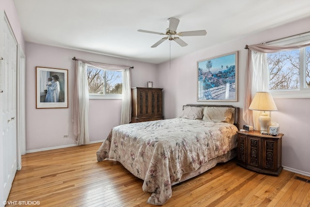 bedroom with visible vents, light wood-style flooring, and baseboards