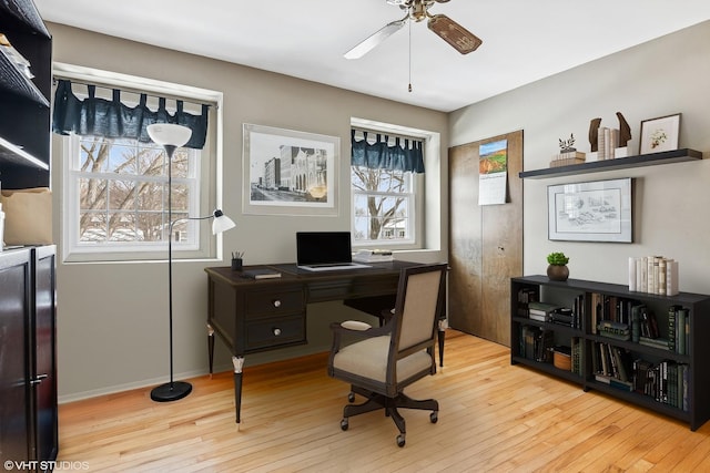 home office with baseboards, a ceiling fan, and hardwood / wood-style flooring